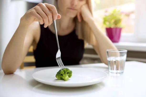 Woman eating Broccolli